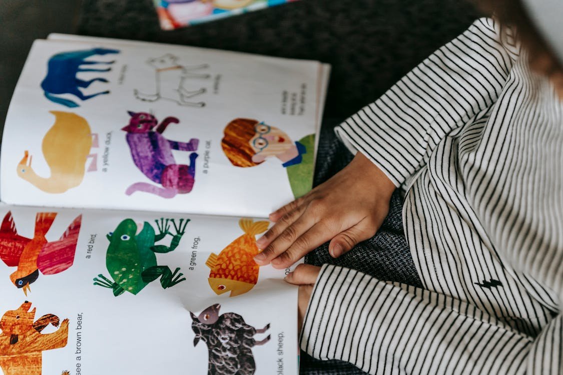 Child looking at colorful illustrated book representing how to create a personalized children's book with Midjourney AI